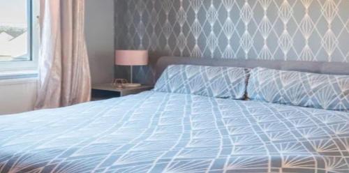 une chambre avec un lit avec une couette bleue et une fenêtre dans l'établissement RueVizelleChalet FantasticChalet, à Courchevel