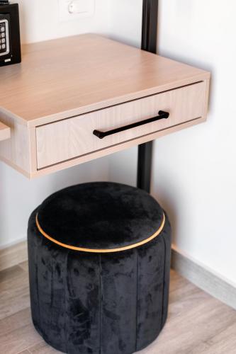 a desk with a black ottoman under a table at Frunze Luxury Apartments in Nafplio