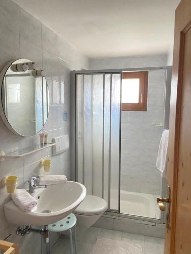 a white bathroom with a sink and a shower at Residence Streitlhof in Tirolo