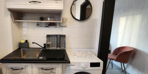 a small kitchen with a sink and a mirror at Morii Lake Studio in Bucharest