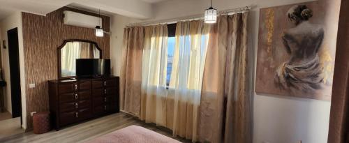 a room with a dresser and a window with a painting at Morii Lake Studio in Bucharest