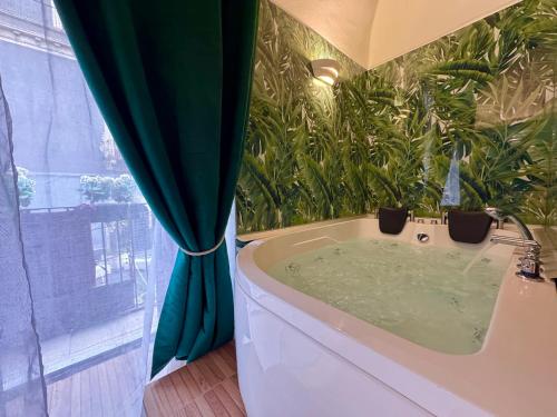 a bath tub in a bathroom with a green plant at CANTU' SUITE in Catania