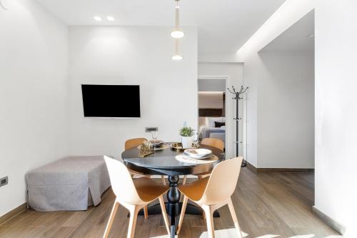 a dining room and living room with a table and chairs at Frunze Luxury Apartments in Nafplio