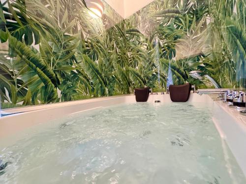 a jacuzzi tub in a room with plants at CANTU' SUITE in Catania