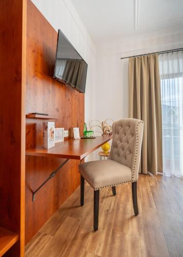 a desk with a chair and a television on a wall at Hotel Krone Tirol in Reutte