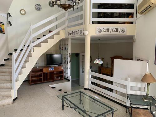 a living room with a glass table and stairs at Magnifique étage de villa à 2 minutes de la plage in Nabeul