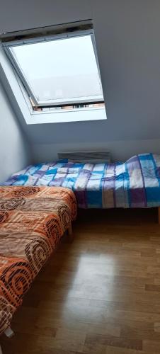 un lit assis dans une pièce avec une fenêtre dans l'établissement Bel appartement T2 150m plage et tous commerces, à Villers-sur-Mer