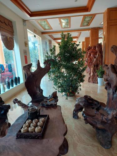 a living room with a table and a tree at Khách sạn Vĩnh Lộc in Lao Cai