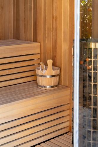 a wooden tub in a sauna with a wooden brush at Frunze Luxury Apartments in Nafplio