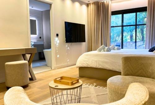 Un dormitorio con una cama, un escritorio y un televisor. en Charming Villa, en Mougins