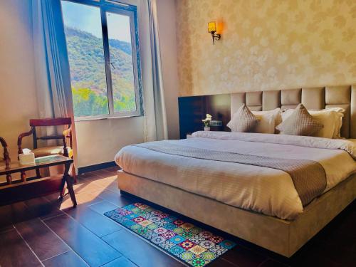 a bedroom with a large bed and a window at Hotel 777 Pushkar - with best mountain view ! swimming pool ! big parking ! lawn with bonfire ! lavish & luxury AC rooms ! top rated ! best selling ! prime location ! property of the year ! in Pushkar