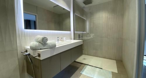 une salle de bain blanche avec un lavabo et un miroir dans l'établissement Charming Villa, à Mougins