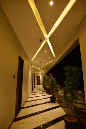 a hallway with potted plants and a ceiling with lights at Hotel 777 Pushkar - with best mountain view ! swimming pool ! big parking ! lawn with bonfire ! lavish & luxury AC rooms ! top rated ! best selling ! prime location ! property of the year ! in Pushkar