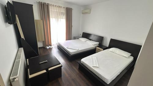 a small room with two beds and a television at Hotel Yjet in Pogradec