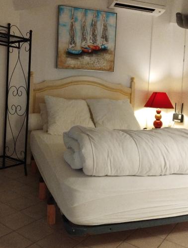 - une chambre dotée d'un lit avec des voiles sur le mur dans l'établissement Les Flamants, 180 m de la Plage, à Saintes-Maries-de-la-Mer