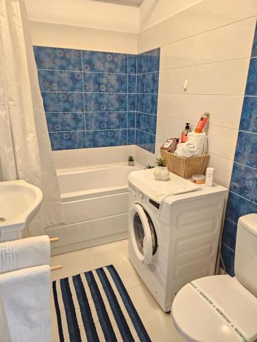 a bathroom with a washing machine and a tub at Enjoy my Home near Palas Mall 2 in Iaşi