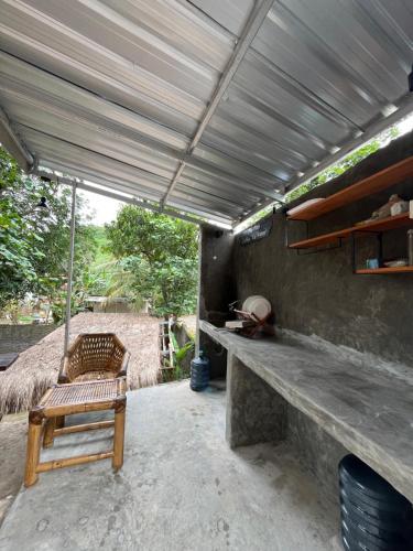a patio with a bench and a hammock on it at Fullmoon homestay in Kuta Lombok
