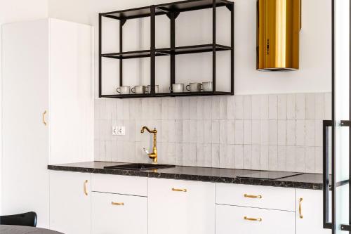 a kitchen with white cabinets and a sink at Kołłątaja 23 Apartments in Wrocław
