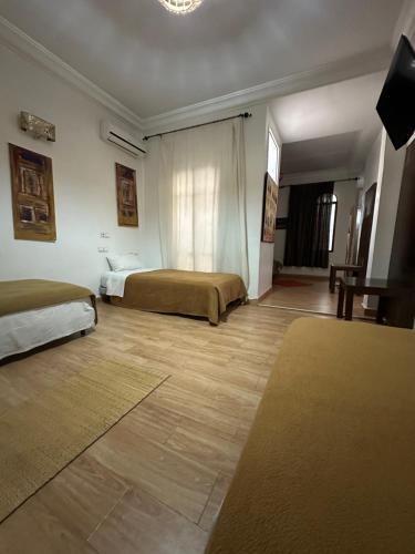 a bedroom with two beds and a television in it at FEKHARA Country Club in Marrakech