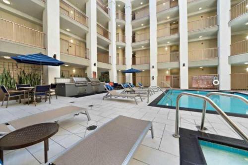 a large building with a pool and tables and chairs at Bright & Spacious in Iconic LA Neighborhood Free parking - 10mins to Cedars in Los Angeles