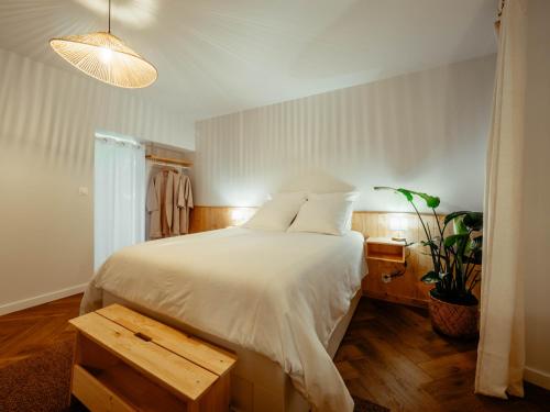 - une chambre avec un lit blanc et du parquet dans l'établissement Appartement Cosy Cœur de la Normandie, à Creully