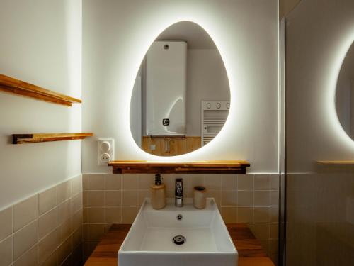 une salle de bain avec un lavabo et un miroir dans l'établissement Appartement Cosy Cœur de la Normandie, à Creully