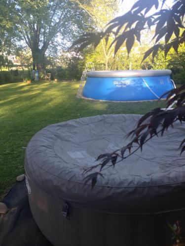- un trampoline bleu dans une cour à côté d'un trampoline dans l'établissement Maison Mignaquy, à Charritte-de-Bas