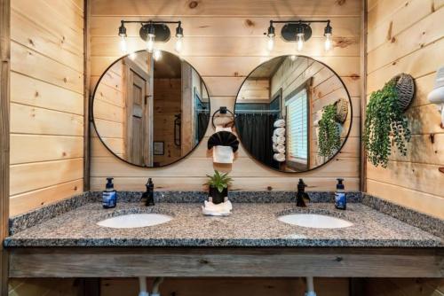un baño con dos lavabos y dos espejos en Tranquil Mountain Getaway By Ghosal Luxury Lodging, en Gatlinburg