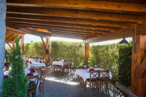 a patio with tables and chairs under a wooden pergola at Hotel Larrañaga in Azpeitia