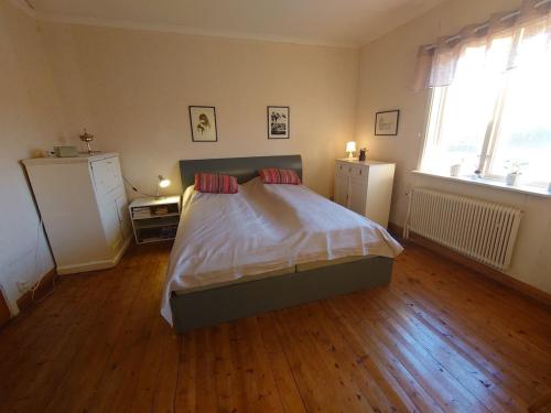 a bedroom with a bed and a wooden floor at Villa i Näsland in Näsland