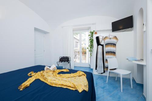a bedroom with a blue bed with a yellow blanket at Secret Amalfi - Your stay in downtown Amalfi in Amalfi