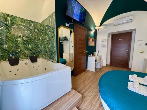 a bathroom with a tub and a large plant wall at CANTU' SUITE in Catania