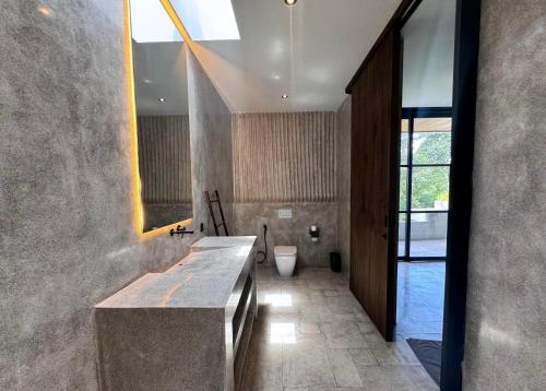 a bathroom with a sink and a toilet in it at Aranya Bali in Tumbak Bayuh