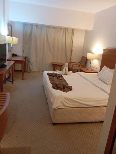 a hotel room with a large bed and a desk at Fully Personal Apartment in Al Malaz in Riyadh