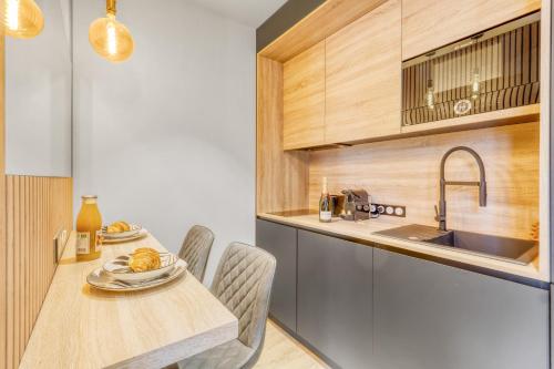 une cuisine avec une table, des chaises et un évier dans l'établissement Hypercentre Studio West à 2minutes du Palais des festivals, à Cannes