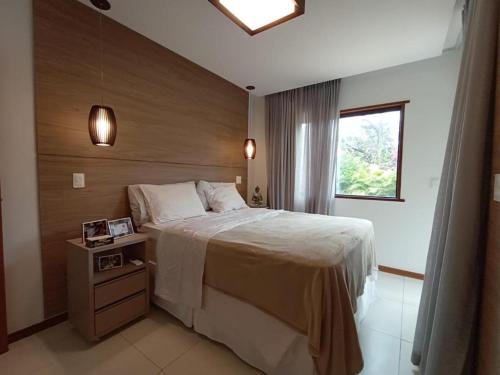 una camera da letto con un letto grande e una finestra di CASA EM PRAIA DO FORTE a Mata de Sao Joao