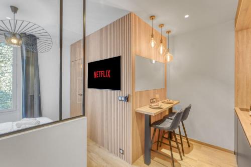 une chambre avec une table et une porte munie d'un panneau. dans l'établissement Hypercentre Studio West à 2minutes du Palais des festivals, à Cannes