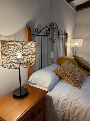 a bedroom with a bed with a lamp on a wooden table at CASA RURAL MASIA ARINESA Culla in Culla