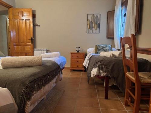 a room with three beds and a chair in it at CASA RURAL MASIA ARINESA Culla in Culla