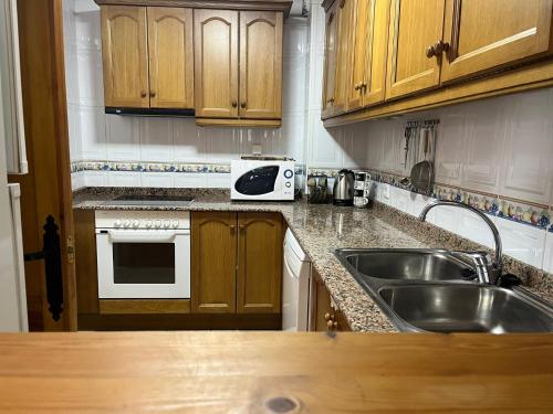 a kitchen with wooden cabinets and a sink at CASA RURAL MASIA ARINESA Culla in Culla