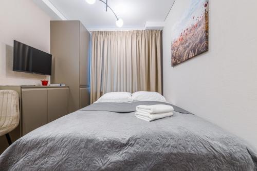 a bedroom with a bed with towels on it at Stylish gray studio near the city center in Vilnius