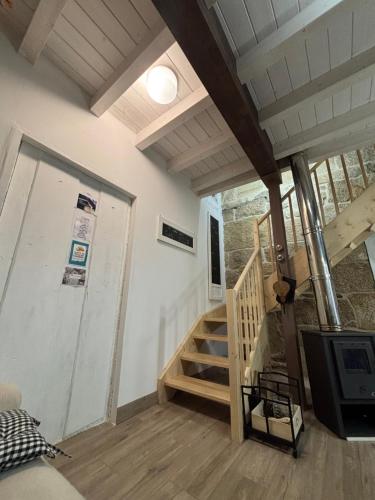 un soggiorno con scala e televisore di Aturuxo a Trasmiras