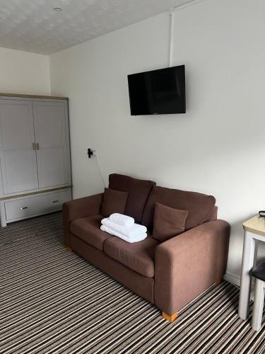 a brown couch in a living room with a tv at Beechwood Lodges in Ballycastle