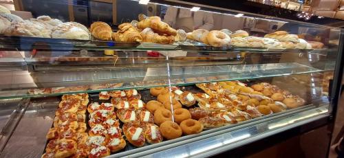 une boulangerie remplie de toutes sortes de pâtisseries différentes dans l'établissement Villa Tàsca Apartment, à Palerme