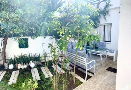 a garden with a bench and a table and trees at 1922 Epoch Harmony Oikia in Volos