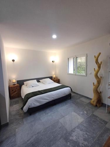 - une chambre avec un lit et une branche d'arbre sur le mur dans l'établissement T3, 8 couchages, grande terrasse, vue mer, parking privé, à La Ciotat