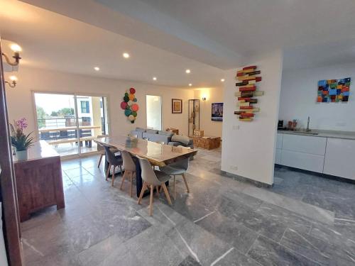 Una cocina y un comedor con mesa y sillas. en T3, 8 couchages, grande terrasse, vue mer, parking privé, en La Ciotat