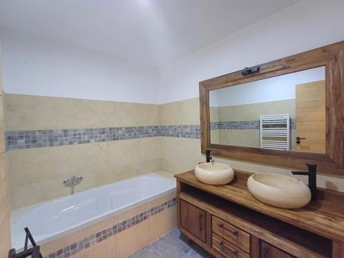 Un baño con bañera y un espejo grande. en T3, 8 couchages, grande terrasse, vue mer, parking privé, en La Ciotat