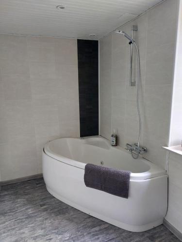 une baignoire blanche dans une salle de bain avec une serviette dans l'établissement Moulin de serre, à Cassagnes-Bégonhès