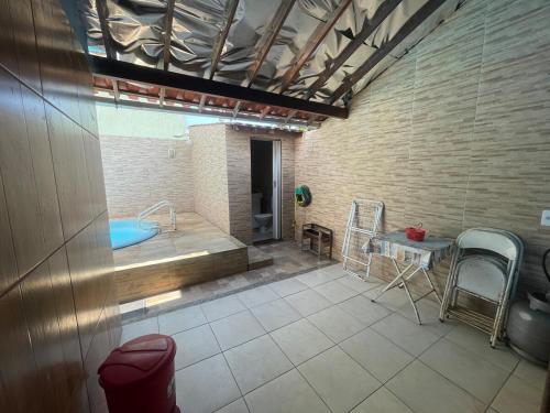 a bathroom with a tub and a table with chairs at Aconchego Long Beach in Cabo Frio